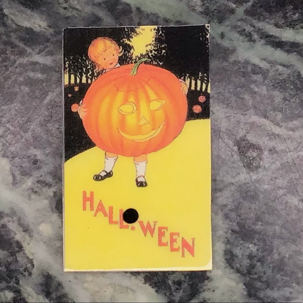 Vintage Halloween girl holding pumpkin pin